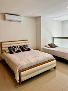 a bedroom with a large bed with two pillows at Apartamentos Cartagena Marbella Suite in Cartagena de Indias