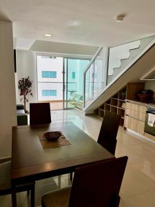 a dining room with a table and a staircase at Apartamentos Cartagena Marbella Suite in Cartagena de Indias