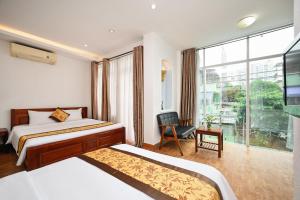 a hotel room with two beds and a window at Queen Hotel Saigon Airport in Ho Chi Minh City