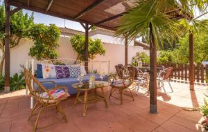 eine Terrasse mit einem blauen Sofa sowie Tischen und Stühlen in der Unterkunft Awesome Home In Chiclana De La Fronter in Chiclana de la Frontera + 24 Fotos