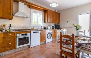 eine Küche mit weißen Geräten und einem Tisch mit einem Esszimmer in der Unterkunft Awesome Home In Chiclana De La Fronter in Chiclana de la Frontera