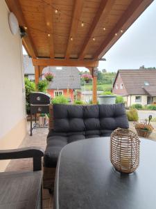 a living room with a couch and a table at Ferienwohnung Schwarzwaldtraum mit gemütlicher Grill-Lounge in Lenzkirch