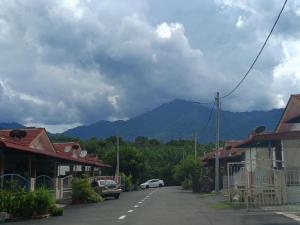 a street in a town with mountains in the background at Seri Raban Homestay in Kampong Kuala Chegar