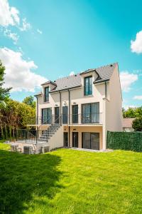 a large white house with a green lawn at Le Cool'Nest - Proche Disney et Val d'Europe 10mn in Esbly