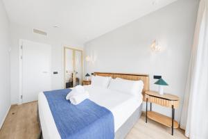 a bedroom with a large white bed and a table at Hotel Ankaa - Adults Only in Porto Cristo