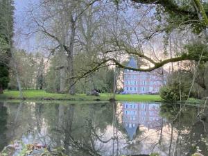 a reflection of a building in a pond in a park at Le Château d'Elbeuf-en-Bray in Elbeuf-en-Bray