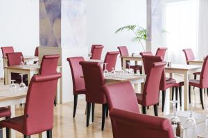 a dining room with tables and red chairs at Hotel Ankaa - Adults Only in Porto Cristo