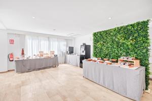 a large green wall in a room with tables at Hotel Ankaa - Adults Only in Porto Cristo