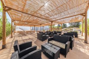 a pergola with chairs and tables on a patio at Hotel Ankaa - Adults Only in Porto Cristo