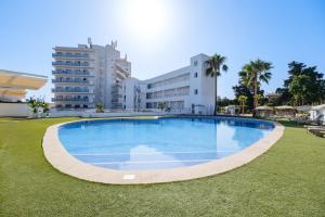 a large swimming pool in the middle of a grass field at Hotel Ankaa - Adults Only in Porto Cristo