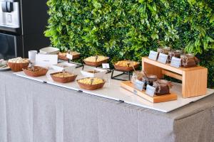 a buffet of food on a table with baskets of food at Hotel Ankaa - Adults Only in Porto Cristo