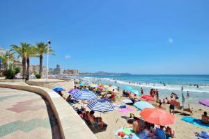 tłum ludzi na plaży z parasolami w obiekcie Xavier - oceanfront apartment with sea views in Calpe w mieście Calpe