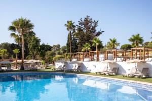 a pool at a resort with chairs and umbrellas at Hotel Ankaa - Adults Only in Porto Cristo