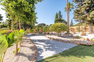 a park with palm trees and a road at Hotel Ankaa - Adults Only in Porto Cristo