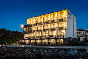 a building on a hill with a blue sky at Sea Stay Hotel in Jeju