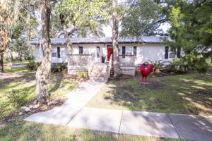 een rode kip die voor een huis staat bij Red Rooster Cottage in Freeport