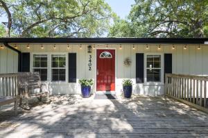 een huis met een rode deur en een bank bij Red Rooster Cottage in Freeport