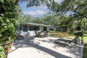 un patio avec un groupe de chaises et une maison dans l'établissement Birdsong Cottage, à Freeport