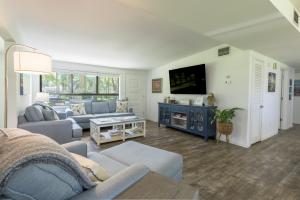 un salon avec un canapé et une télévision dans l'établissement Birdsong Cottage, à Freeport 23 autres photos