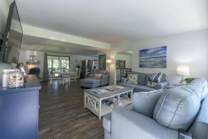 un salon avec un canapé et une table dans l'établissement Birdsong Cottage, à Freeport