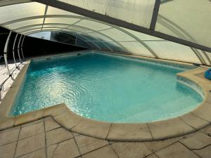 a large pool of water in a building at Maison 4 personnes avec piscine in Bourriot-Bergonce