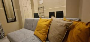 a couch with yellow pillows in a living room at City Center Mindelo 37 in Mindelo
