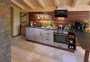 a kitchen with a sink and a stove at ÜbermAlztal Chalet Alzblick Ferienwohnung in Altenmarkt an der Alz +2 photos