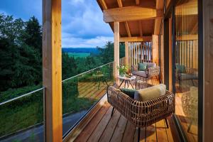 a screened in porch with wicker chairs and a table at ÜbermAlztal Chalet Alzblick Ferienwohnung in Altenmarkt an der Alz