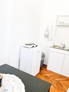 een keuken met witte kasten en een tafel bij Rise of Olympus apartmani in Zadar +62 foto's