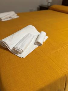 due asciugamani bianchi posti sopra un letto di La Palma Home a Ali Terme