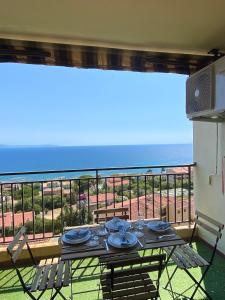 - une table sur un balcon avec vue sur l'océan dans l'établissement VUE MER EXCEPTIONNELLE !! Studio calme et lumineux sur la prestigieuse route des Sanguinaires à Ajaccio, à Ajaccio