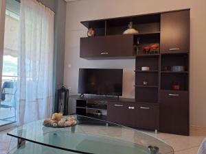 a living room with a tv and a glass table at Victoria's house in Kalamata