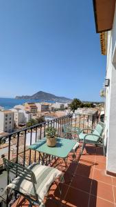 Un patio con una mesa y sillas en un balcón. en Casa con vistas al mar en el Casco Antiguo de Altea, en Altea