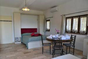 a bedroom with a bed and a table and chairs at Dimora dei Cardinali in Agropoli