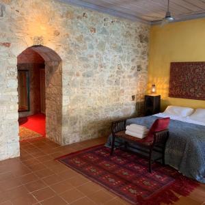 a bedroom with a bed and a chair in a room at Mediterraneo Hotel in Meyisti