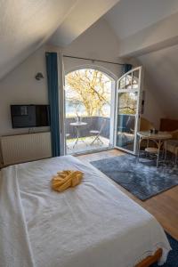 a bedroom with a large bed and a large window at Strandvilla Drei Mäderl Haus in Boltenhagen