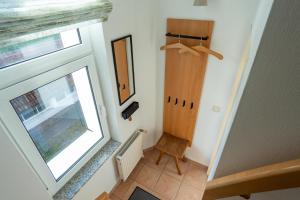 a small hallway with a window and a chair at Strandvilla Drei Mäderl Haus in Boltenhagen +101 photos