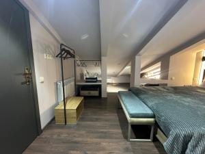 1 dormitorio con cama y banco. en Mansarda House, en Tiflis