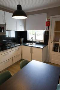 a kitchen with a table with chairs and a sink at Alojamento Raízes da Montanha RRAL 4596 in Madalena