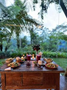a wooden table with plates of food on it at Castle in the sky mountain bliss, Kintamani area in Plaga +115 photos