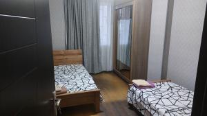 Una pequeña habitación con una cama y un espejo. en Tukhudo, en Tiflis