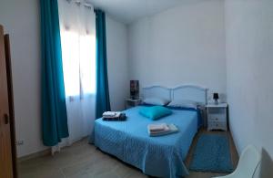 a bedroom with a bed with blue sheets and a window at Suite Da Ninna 1 in Allai