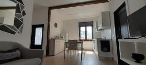 a living room with a table and a kitchen at Suite Da Ninna 1 in Allai