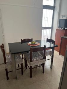 tavolo da pranzo con sedie e piatto di frutta di La Palma Home a Ali Terme Altre 5 foto