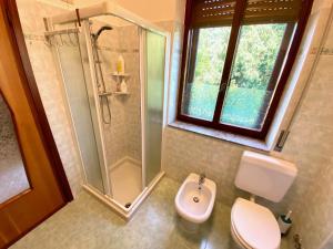 a bathroom with a shower and a toilet and a sink at Villa Cuten in Calco