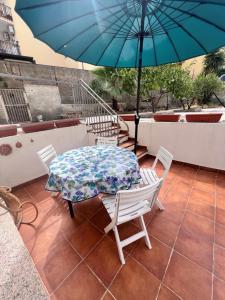 un tavolo e sedie con ombrellone blu su un patio di La Palma Home a Ali Terme