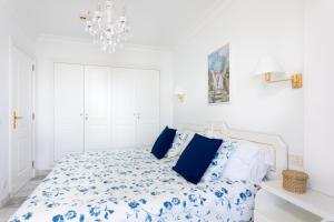 a white bedroom with a blue and white bed at EDEN RENTALS Fabulosas Vistas al Mar y Los Acantilados in Acantilado de los Gigantes