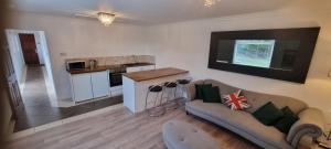 a living room with a couch and a kitchen at Laighdykes Guest Cottage in Saltcoats +9 photos