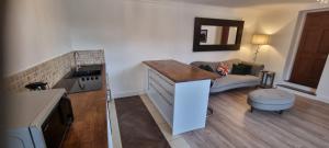 a kitchen with a counter and a living room at Laighdykes Guest Cottage in Saltcoats