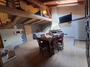 a dining room with a table and chairs and a bedroom at La Maison du Coeur - Hearts in Harmony in Oulx
